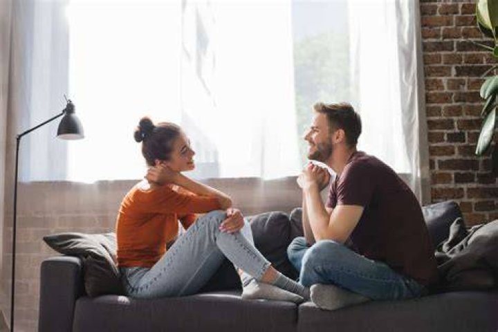 A couple in orange talking on Wife Swap at home