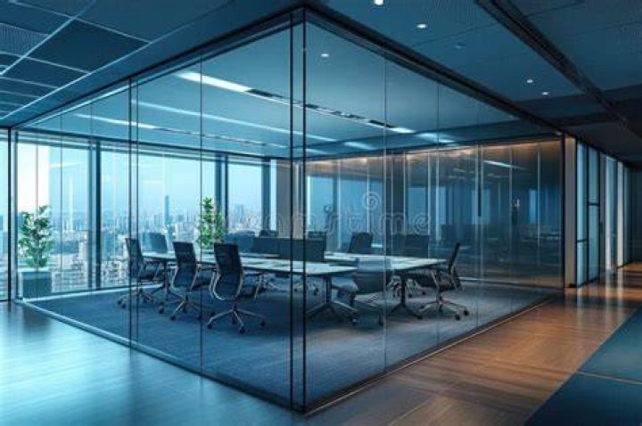 a glass walled room with a view of a mountain and a lake