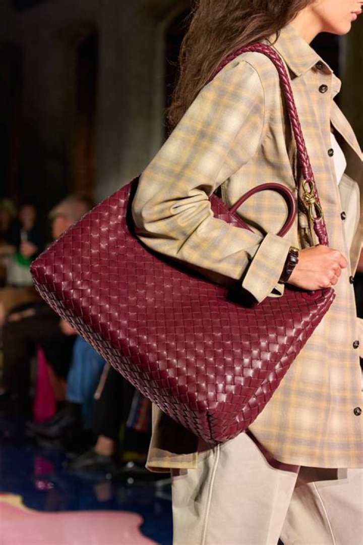 a model at bottega veneta carries an extra large woven bag