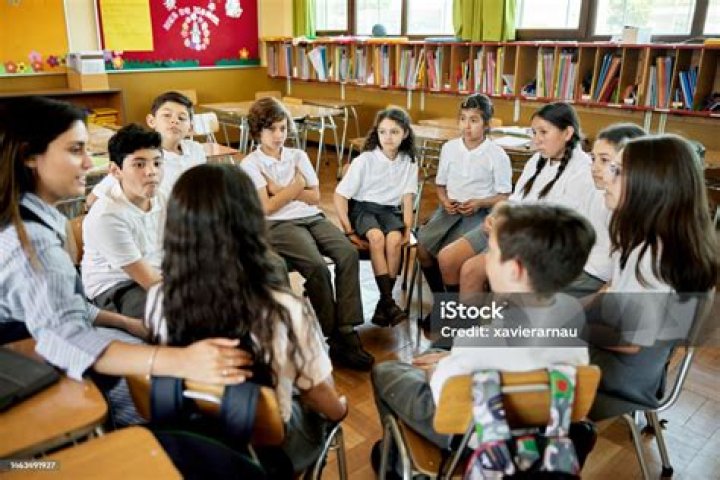A teacher and students sat together at a table.