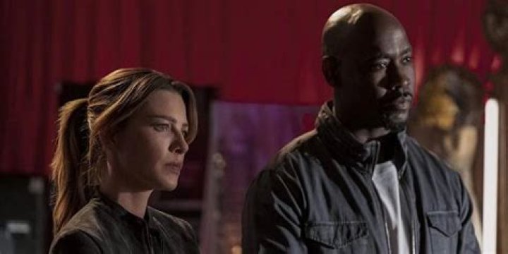 Amenadiel standing next to Chloe and looking sideways in a still from Lucifer