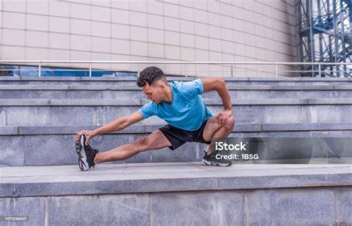 athlete stretching knees before working out