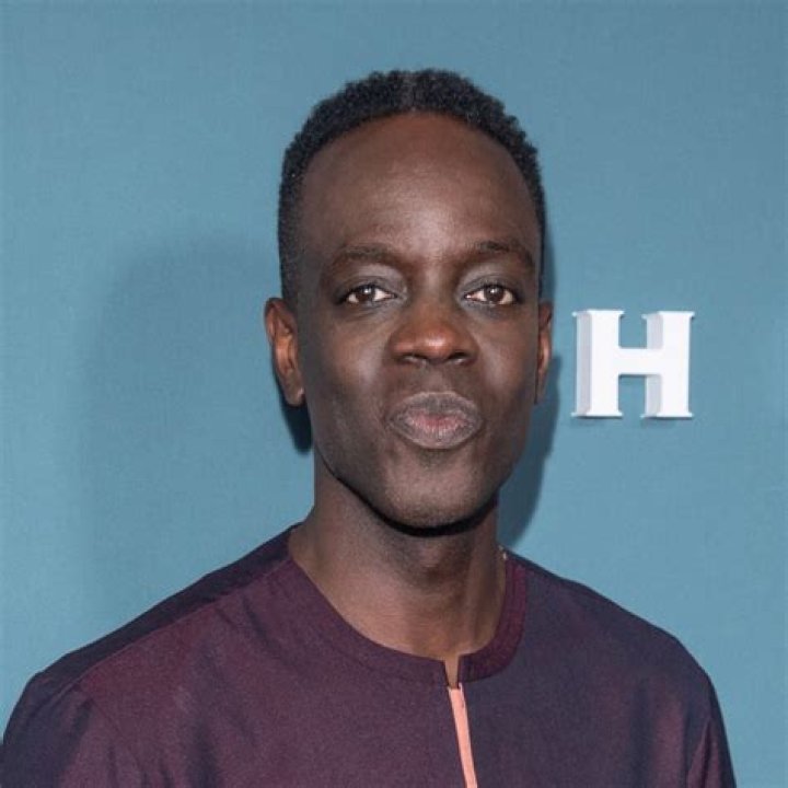 Ato Essandoh holds up two shirts in The Diplomat