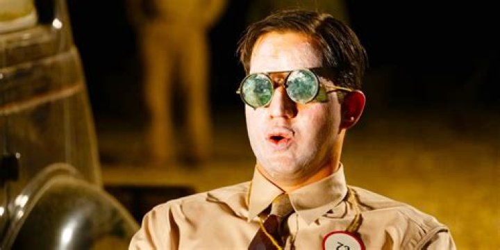 Benny Safdie wearing goggles, his face smeared in sunscreen, as he prepares for the Trinity test in Oppenheimer