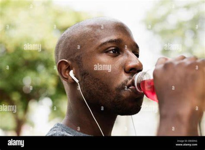 black runner drinking juice in city