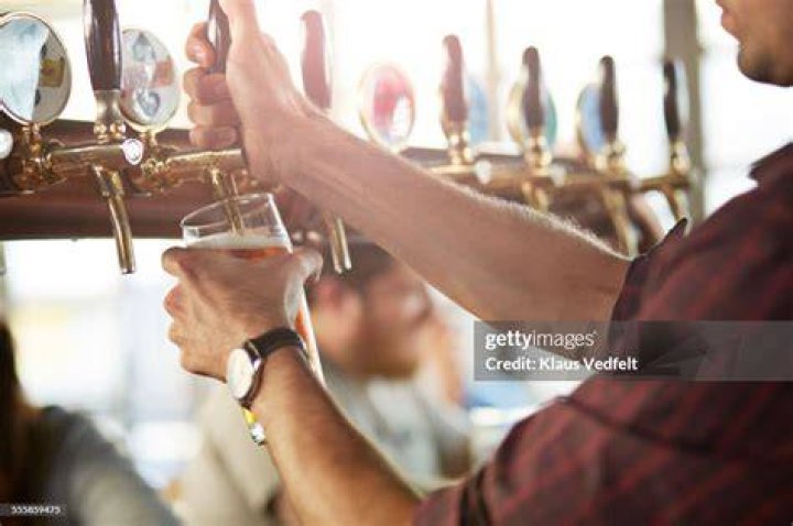 Close-up of bartender making cask beers at bar