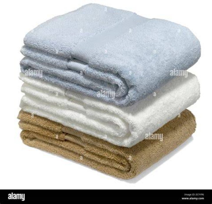 Close-up of folded bath towel on concrete background, top view