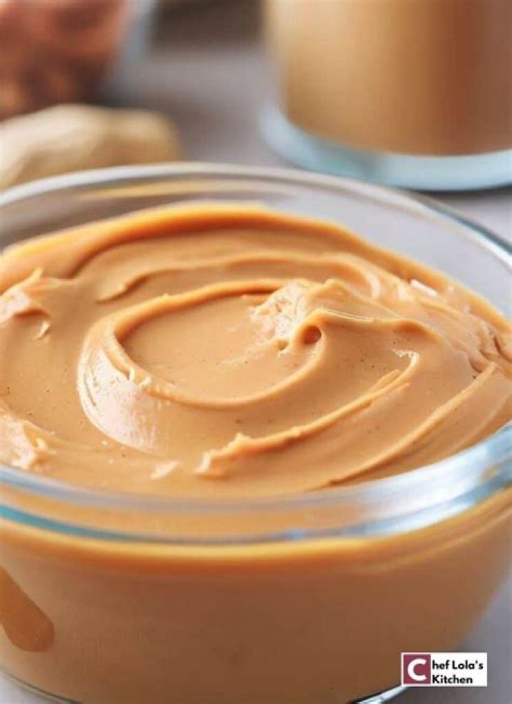 creamy and smooth peanut butter in jar on wood table