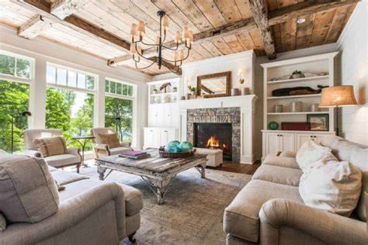 Elegant farmhouse living area with sofas and easy chairs and patio doors open on to garden