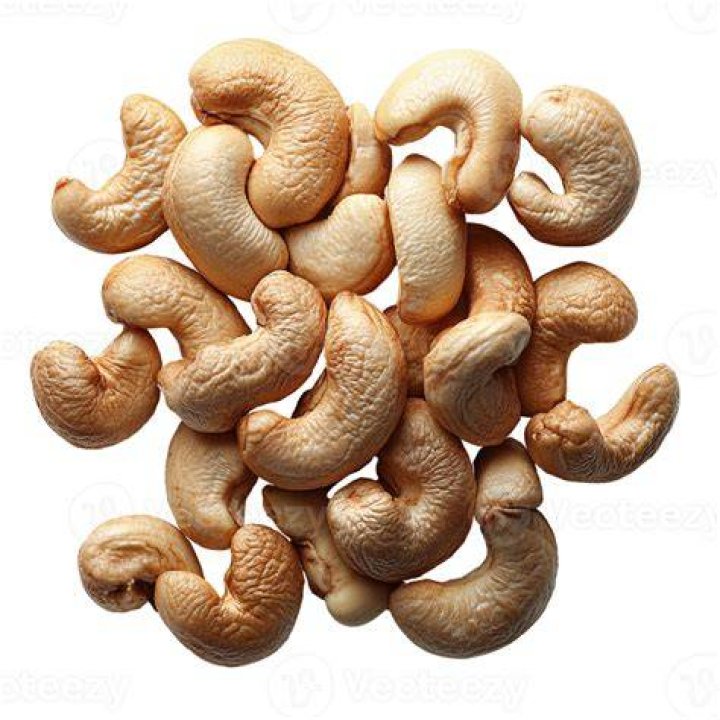 flat lay of cashew in glass bowl with yellow background