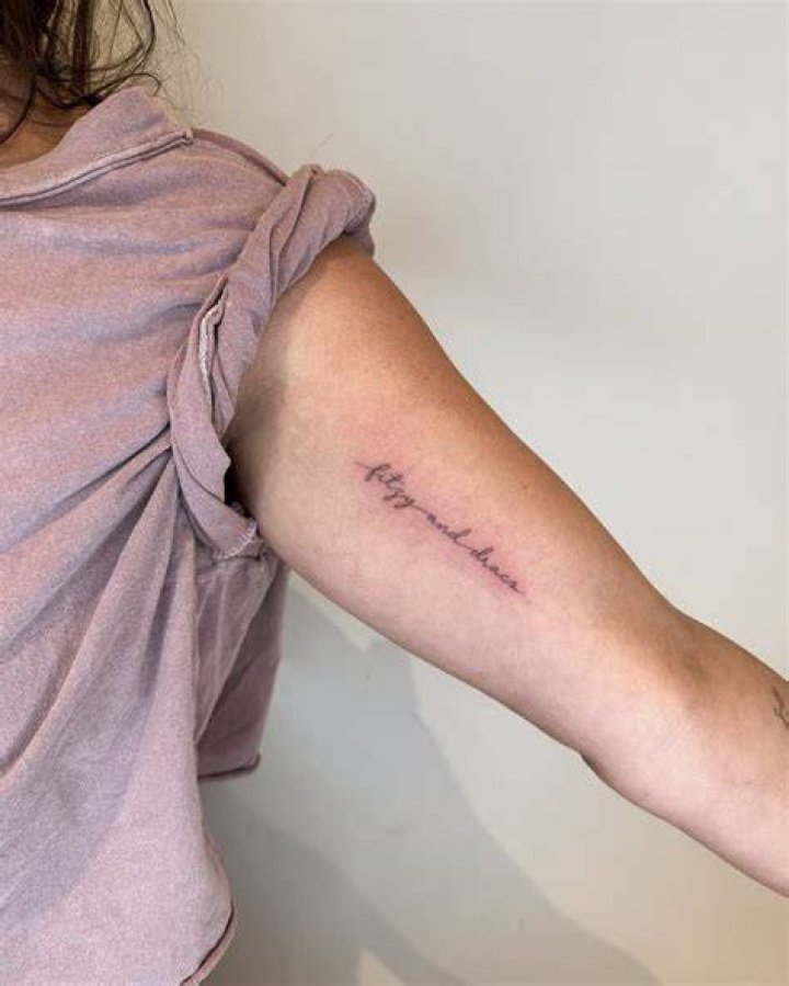 Handwritten lettering tattoo located on the inner arm.