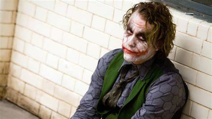 Heath Ledger as The Joker sitting in a cell in The Dark Knight