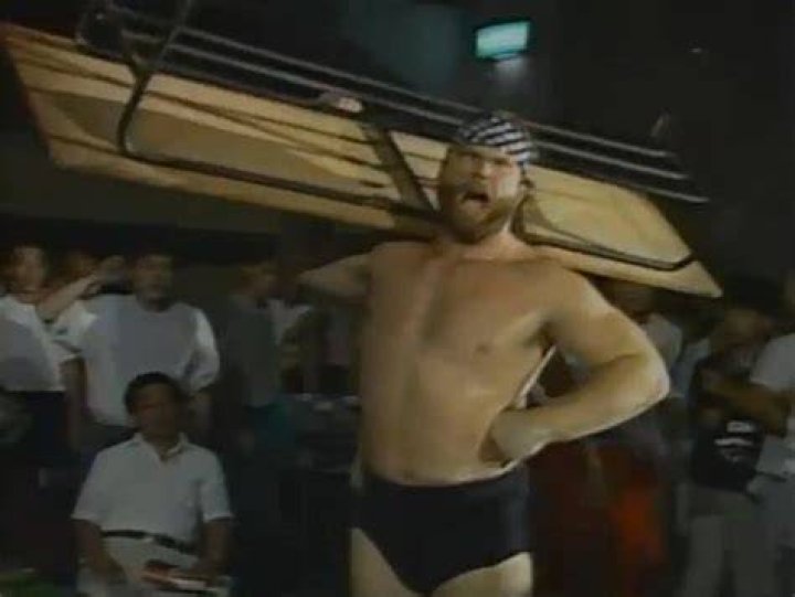 Jim Duggan carries a table in New Japan Pro-Wrestling
