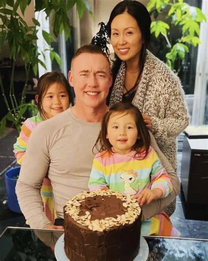 Kevin posing with his wife and daughter