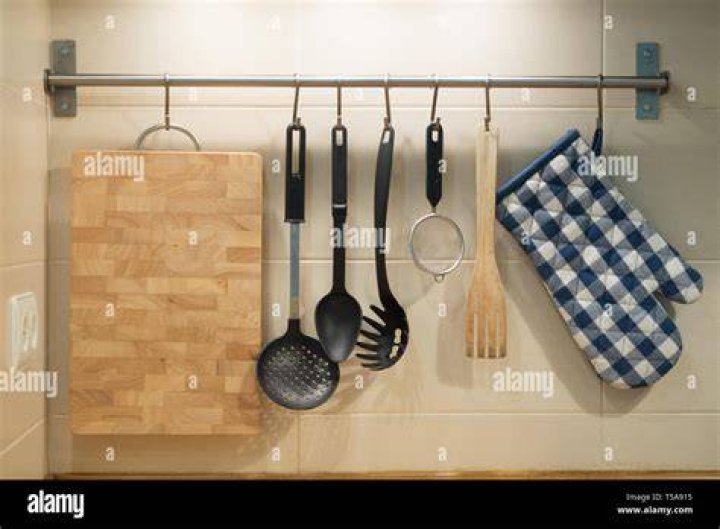 Kitchen Utensils Hanging On Wall At Home