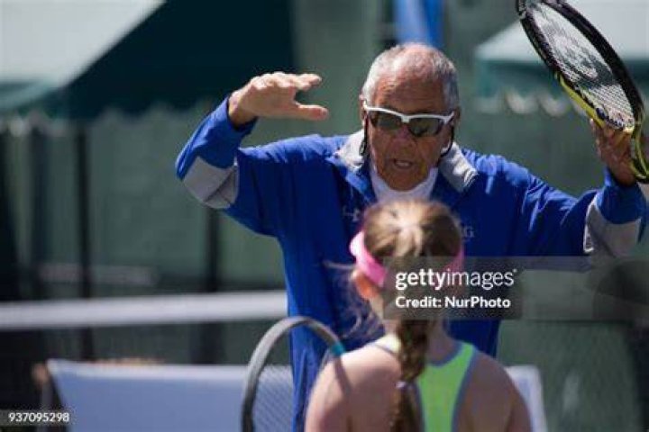 Legandary Coach Nick Bolletieri, from IMG Tennis Academy coaching one of his students in one of Miami Open's secondary courts. IMG academy is the best tennis academy in North America