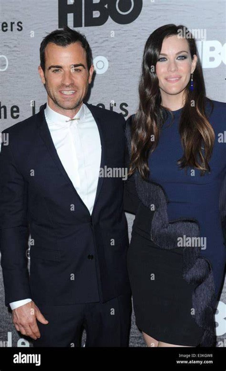 Liv Tyler and Justin Theroux from 'The Leftovers' standing side by side, staring intently into the distance.