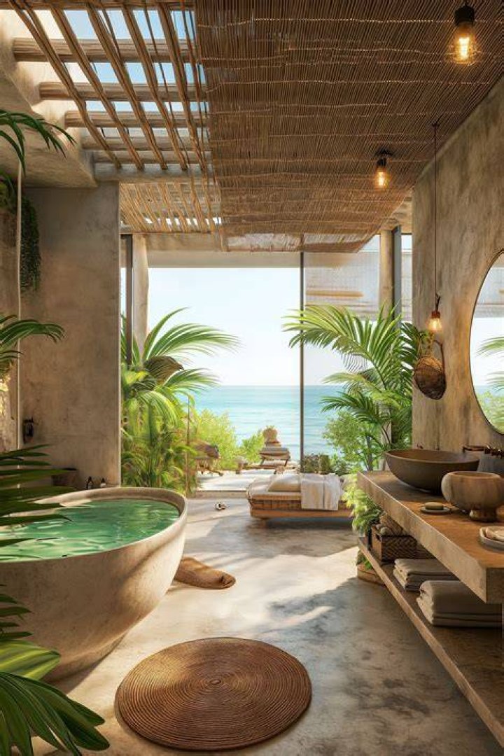 Luxury Interior Tropical Bathroom Of The Dream with a Bathtub and open ceiling, tropical plants and gravel surround the tub with the toilet and showerr glass in the foreground