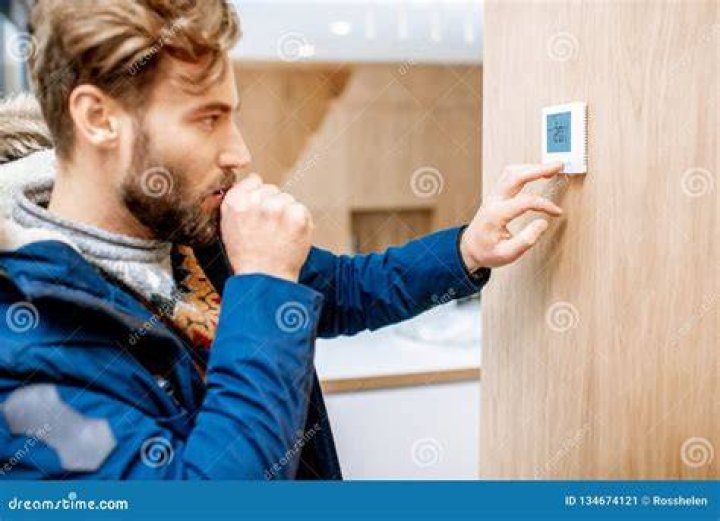 Man adjusting the thermostat