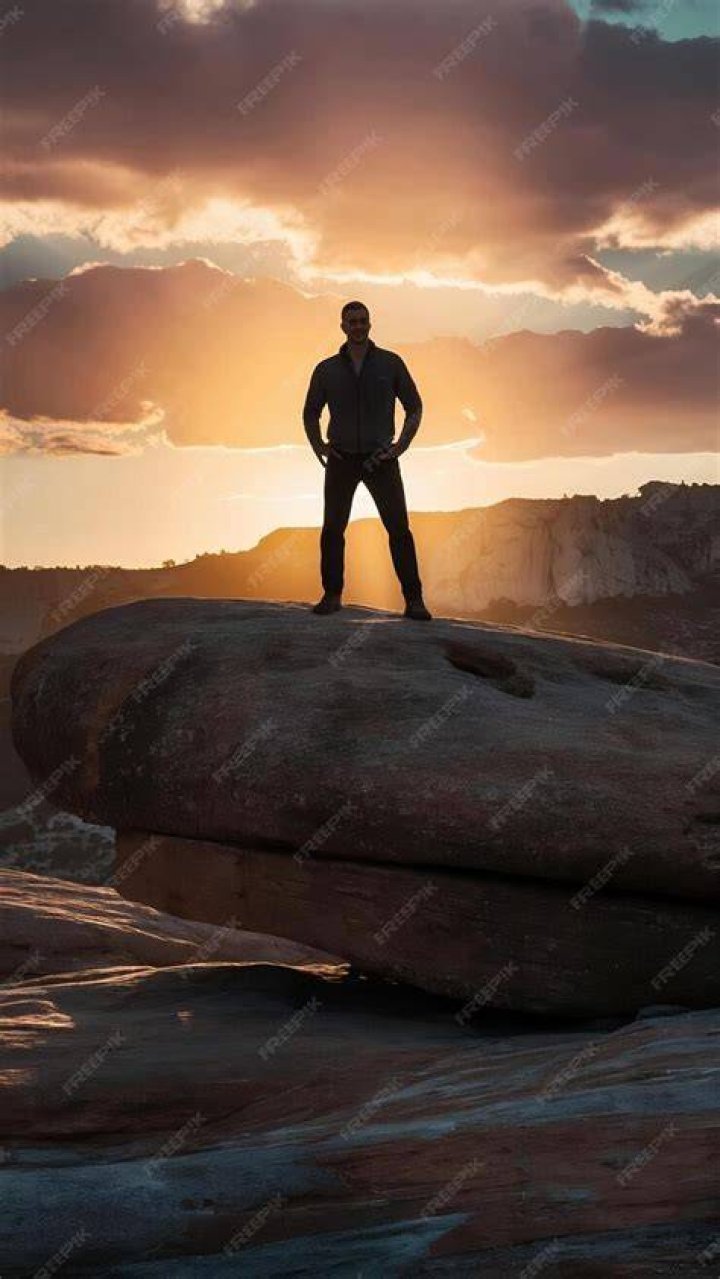 Man standing on a rock looking at view, Highlands, Scotland, UK