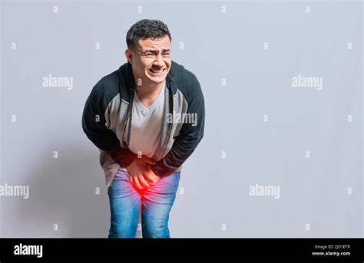 man with hand over crotch