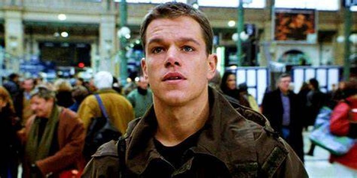 Matt Damon as Jason Bourne holding a gun
