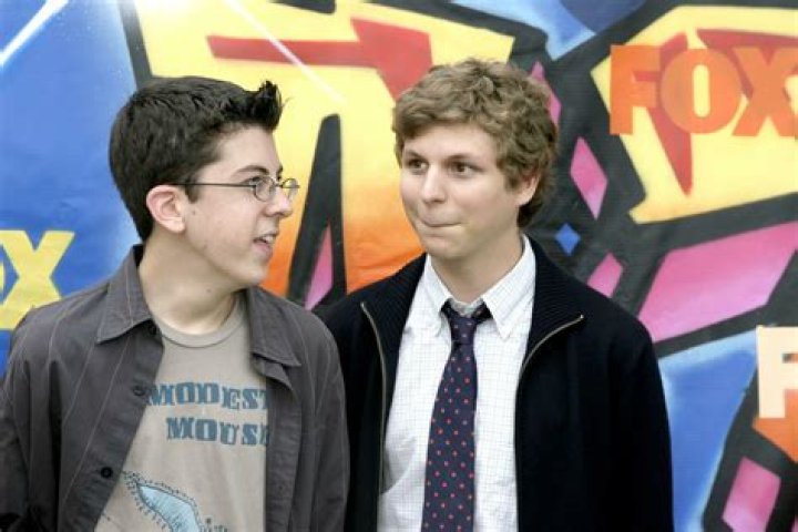 Michael Cera, Christopher Mintz-Plasse, and Jonah Hill looking at a laptop in Superbad.