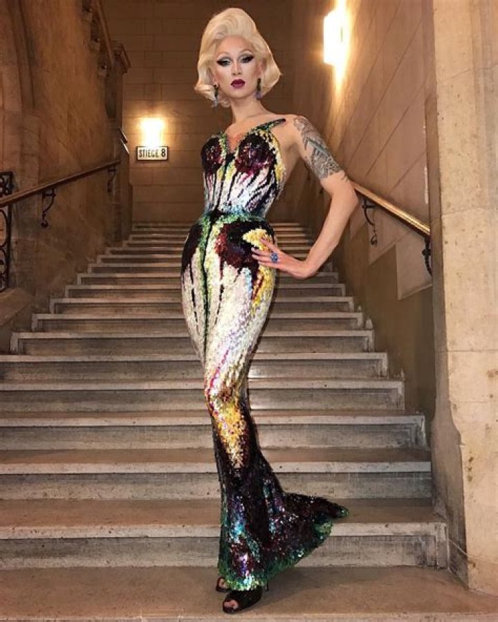 Miss Fame wearing a mask and looking sideways in the music video for Rubber Doll