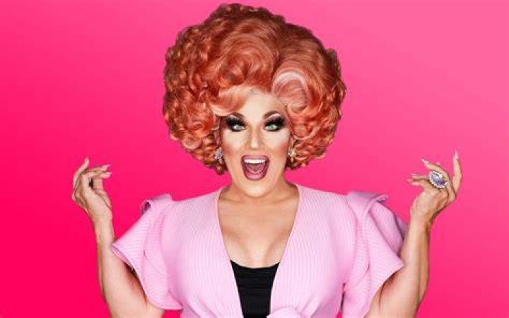 Mrs. Kasha Davis holds a balloon above her head in a RuPaul's Drag Race promo photo