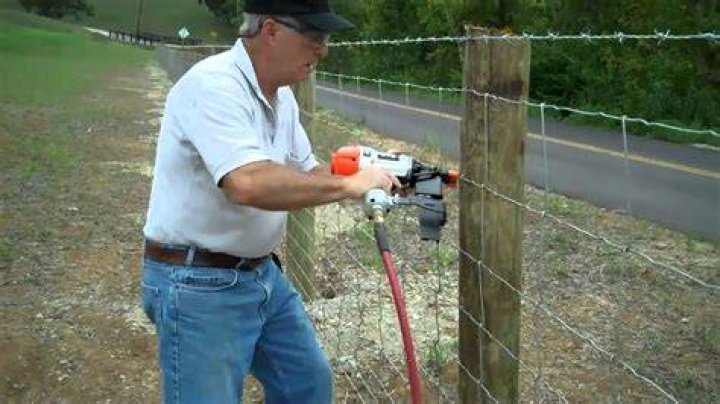 Nailing a wire fence on a post
