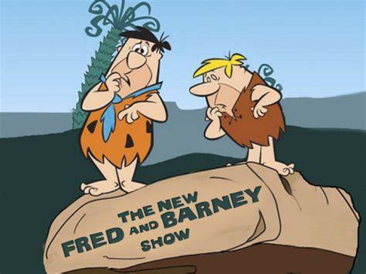 Portrait of Fred And Barney Smiling With The StoneAge Behind Them