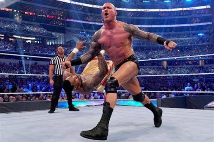 Randy Orton dropping a knee on Triple H.