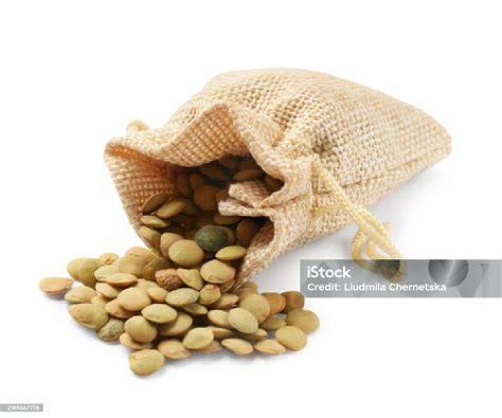 raw lentils in sack on white background