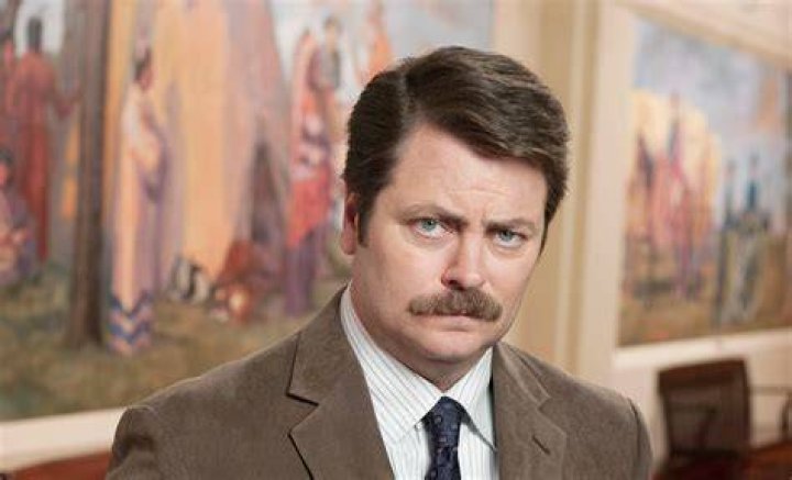 Ron Swanson looking up at someone from his desk in Parks and Rec