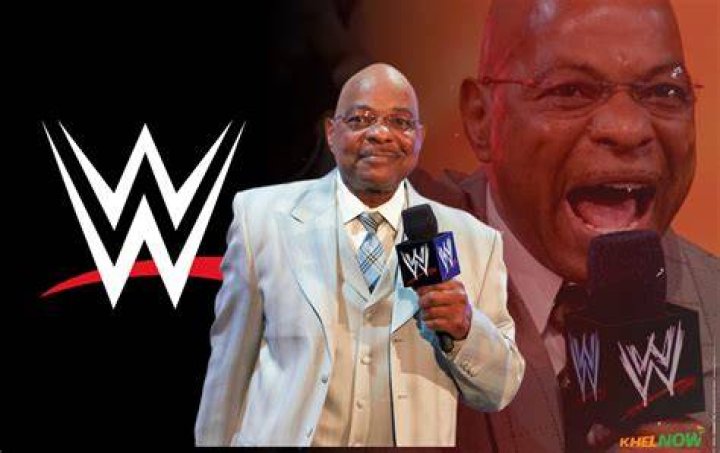 Teddy Long in the ring wearing a baby blue suit.