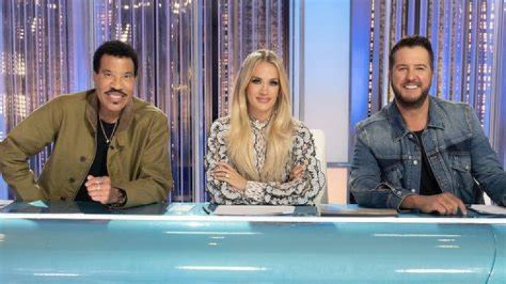 The judges of American Idol sitting at a table