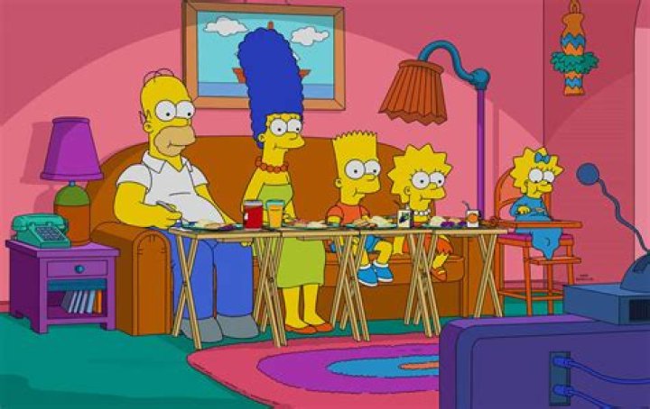 The Simpsons eating dinner in front of the TV