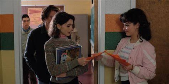 Tina handing Nancy a Halloween flyer in Stranger Things.