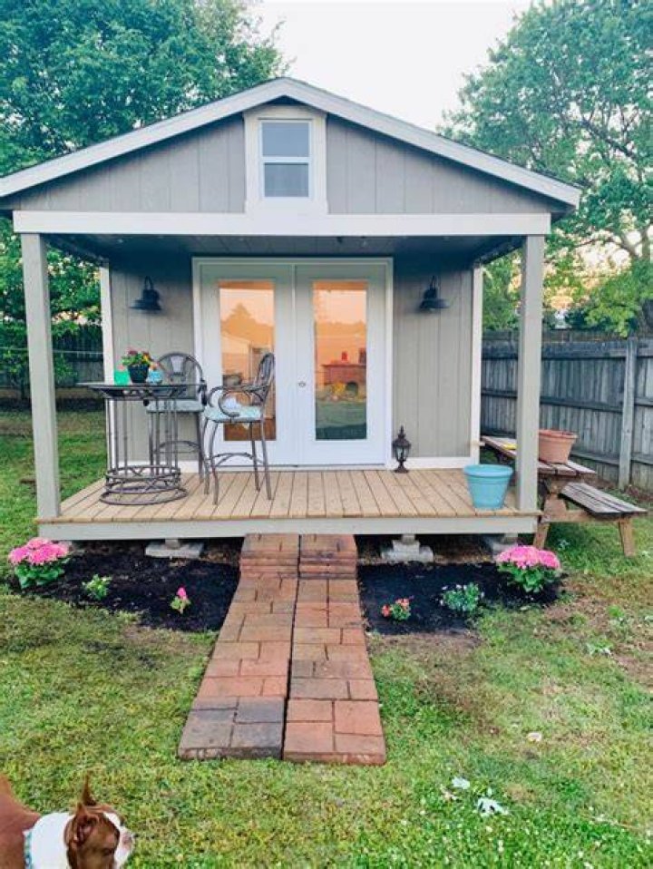 tiny home she shed with a white farmhouse style kitchen and stove