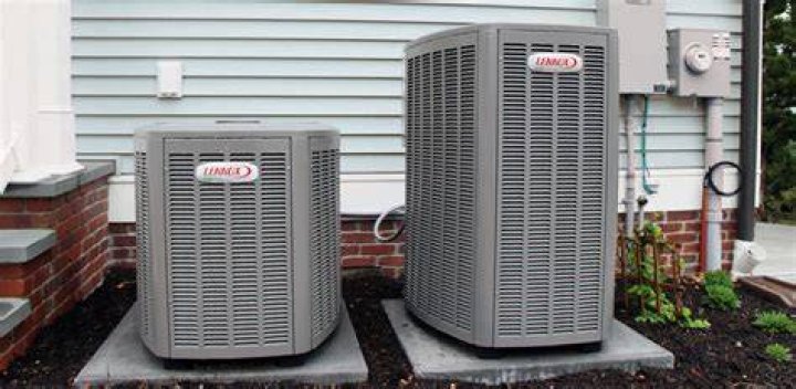 two central air conditioning units outside of house