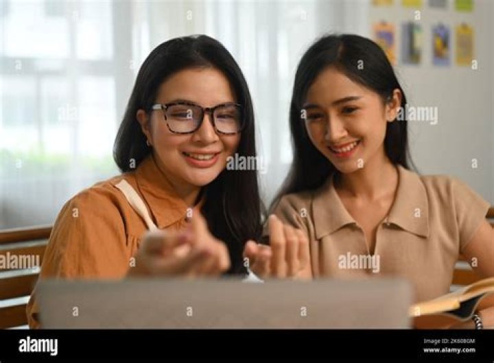 two students looking at a laptop
