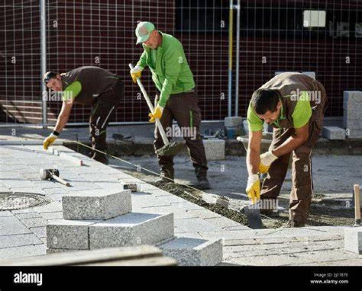 Volunteers laying cement at a construction site