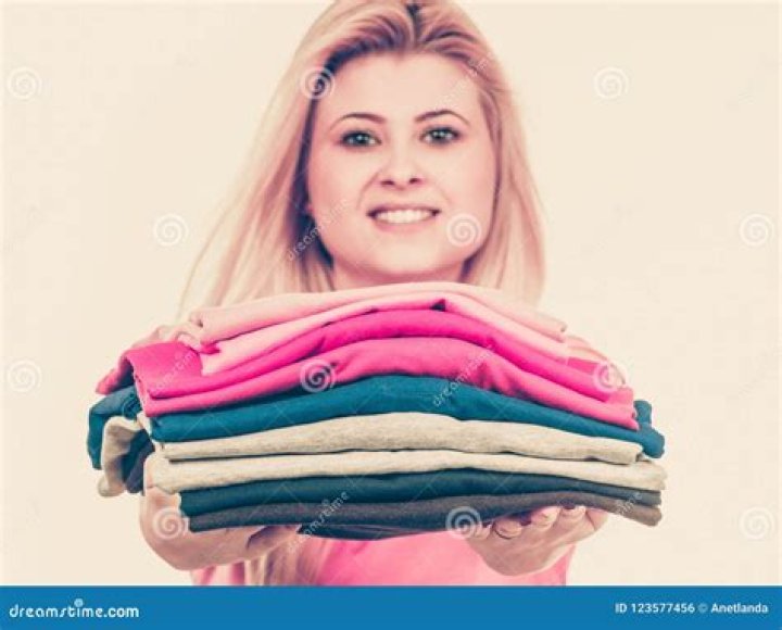 Woman Holding A Pile Of Bedding For Sleeping