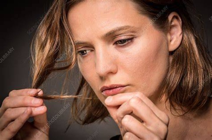 Woman inspecting hair roots