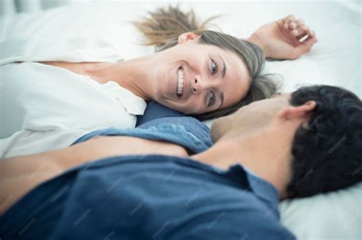 young couple in love lying embracing in bed