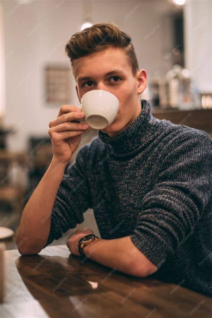 young man drinking coffee in office